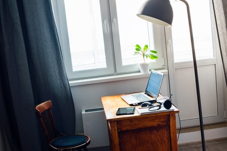 Interior of Home Office Laptop Computer Earphones Mouse Notebook Pencil Document Stuff on Vintage Wooden Working Table Life Styleの写真素材