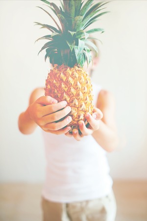 Ripe Juicy Fruit Pineapple in Hands Little Boy Concept of Healthy Food for Childrenの写真素材
