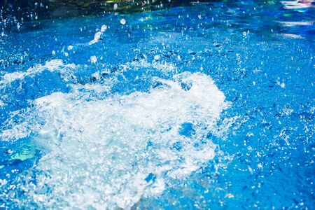 Splash in Swimming Pool from Child's Jump Blue Waterの写真素材