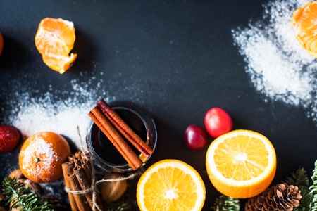 Mulled Wine Hot Drink with Spices Citrus Fruits Oranges Tangerines Apples Black Background Christmas Beverage Copy Spaceの写真素材