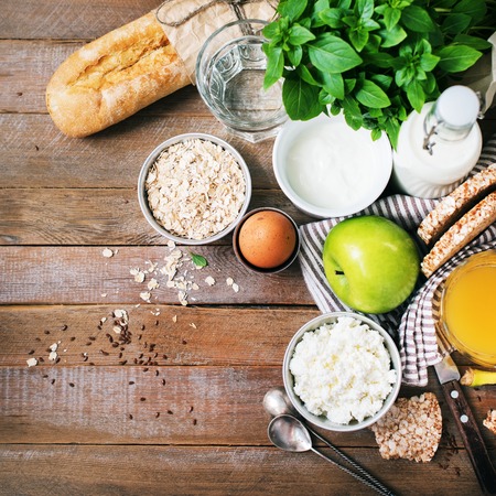 Ingredients Healthy Breakfast Egg Oatmeal Fruits Milk Yogurt Orange Juice Small Loafs Cheese Banana Apple Dietetic Food on Wooden Rustic Background Top Viewの写真素材