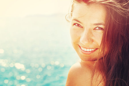 Smiling Suntanned Woman On the Background from Blue Sea in Sunlights. Summer dayの写真素材
