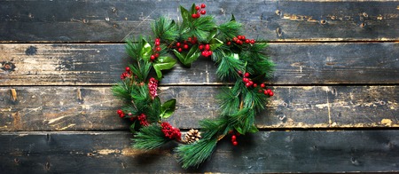 Holiday Banner Green Christmas Decorative Wreath on Dark Planks Wooden Vintage Background top view Happy New Year greeting card Winter xmas theme flat lay. Copy Space for textの写真素材