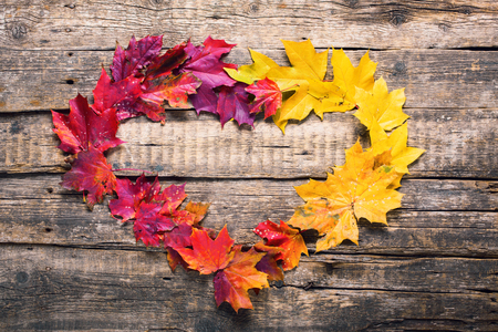 heart shape frame red yellow maple leaves fall wooden vintage background thanksgiving holidayの写真素材