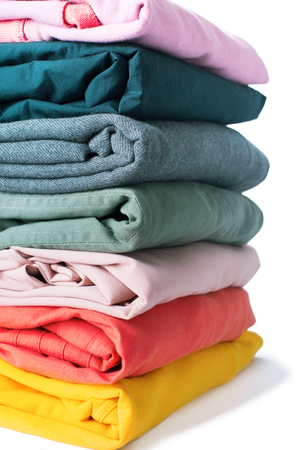 stack pastel warm colorful textiles cotton clothes background closeup isolated on whiteの写真素材