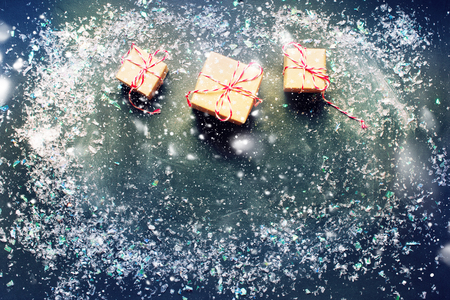 Tree Festive Gifts Boxes with Snow on Dark Holiday Background. Copy Space for Text Happy New Year or Merry Christmas Winter Greeting Card Xmas Decorative and Drawing Snowの写真素材