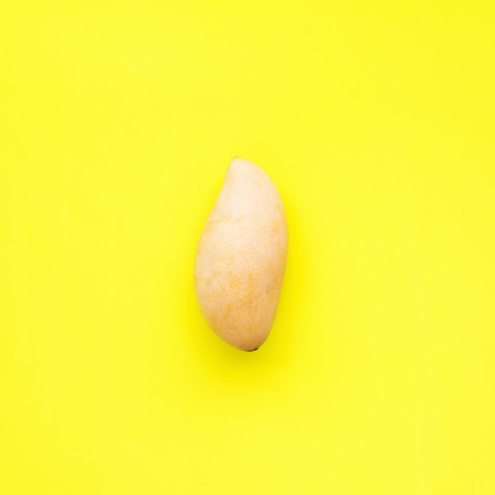 Mango One Whole Tropical Fruit Yellow Background Object Useful Natural Organic Food Style Minimalism Top View Flat Layの写真素材