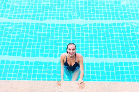 Beautiful Young Suntanned Woman Blonde Long Hair Bathing Suit Black Swimming Pool Resort Suntan Skin Holiday Vacation Outdoorの写真素材