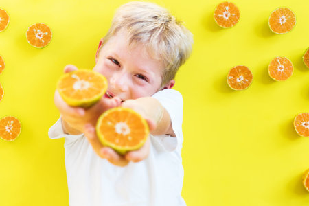 boy child white t-shirt smiling posing have fun with tropical summer fruit tangerine yellow bright...