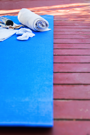 Set for exercises yoga bottle water blue rug white towel background open air morning time equipmentの写真素材