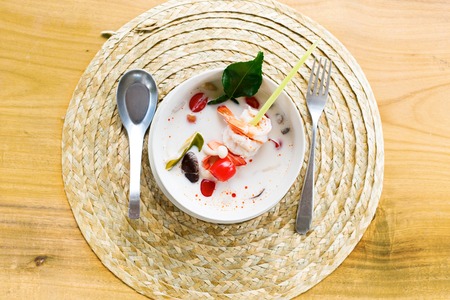 Tom Kha Shrimp soup with coconut milk Thai food straw napkin wooden tableの写真素材