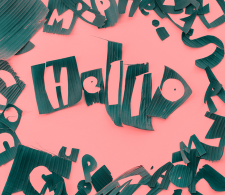 Word HELLO letters from green tropical palm leaves on pink texturedの写真素材