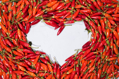 Fresh organic vegetable red hot chili pepper heart shape on grey background. Country style. Frame