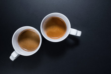 Fresh cups espresso coffee with milkon black background. Top view. Flat lay. Food minimalism concept