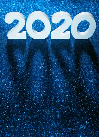 Volume letters 2020 New Year numbers standing on blue bright sparkles background. Holiday festive concept. Christmas decoration. Flat layの写真素材