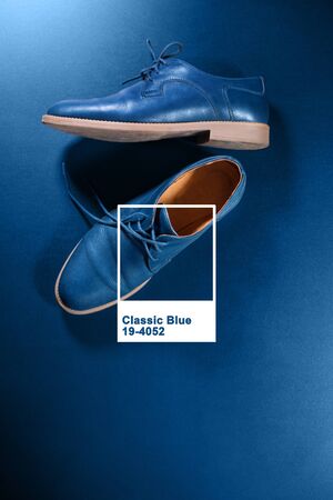 Blue men's leather shoes on dark background. Classic clothers accessory minimalism Top view. Frame and text above image color of the yearの写真素材