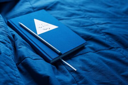 Daily log and pencil on blue plaid. Trend colors of the year 2020. Home interior detail. Planning of bussinesの写真素材
