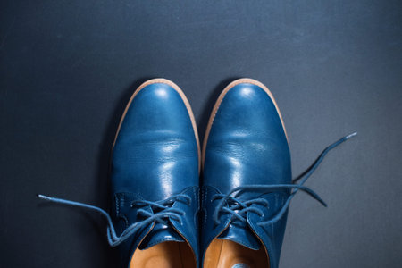 Blue men's leather shoes on dark background. Classic clothers accessory minimalism Top view