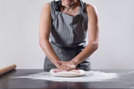 Hand-stretching dough by female hands at home. Preparation of pastry for samsa making. Stay and cooking at home. Quarantine. Isolation. Homemade.の写真素材