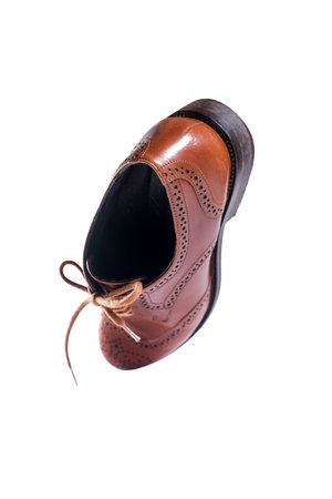 Classic brown leather shoes in perspective and isolated on white background. Flying of objects....