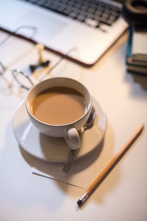 Coffee with milk omn white table at home working place with computer lap top, cup hot beverage, Remotely at home place. Stay at home working online during the quarantine. Online education. Crisisの写真素材