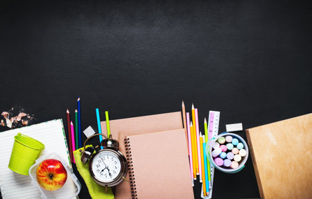 Concept Back To School Alarm Clock Color Chalk Pencil Apple Notebook Stationery on Black and...
