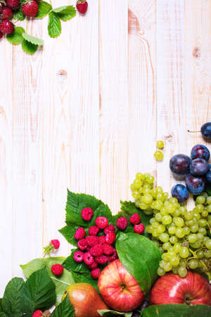 Assortment Fruits Berries Apple Grape Strawberry Damascene with Leaves White Wooden Country Background Health Care Natural Concept Top View Frame Compositionの写真素材