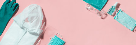 Folding medical protective clothing uniform, masks, glasses and sanitiser on pink background. Stop coronavirus. Finished pandemic crisis. End quarantine. Victory over covid-19. Mask off.の写真素材