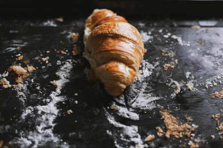 Morning croissant on the black baking tray. French food dessert. Remainder after partyの写真素材