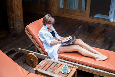Business woman working on the computer outdoor on her vacation. sunbed. outdoor. vacation. summerの写真素材