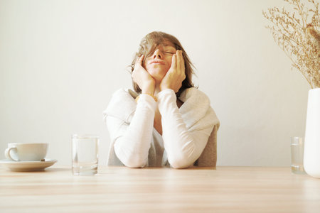 Woman is sitting ina cafe wiyh tooth ach. Boring.