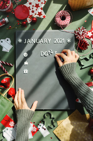 A woman creates a plan for a year on a typesetting plastic board in white letters. Calendar flat...