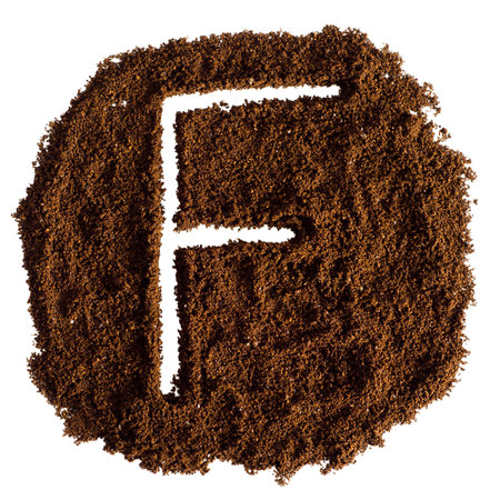 f letter on ground coffee texture isolated on white background, top viewの写真素材
