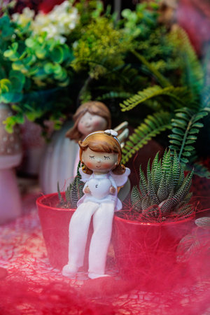 Festive Valentine s Day tabletop display with heart candles, romantic figurines, ceramic lanterns, and lush greenery, arranged in a cozy, colorful decorative sceneの写真素材