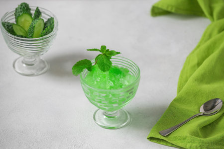 Summer Sicilian dessert granita, frozen juice of fresh cucumber and mint on a white background. Summer cooling, tonic cocktail of crushed ice, a kind of sherbet.の写真素材