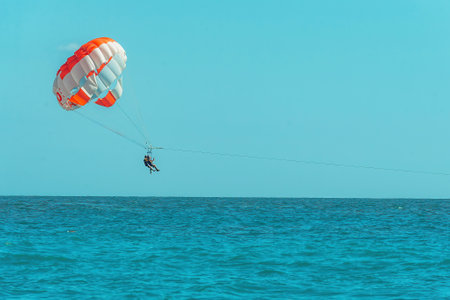 people spend active leisure during holidays at sea, paragliding over waterの写真素材
