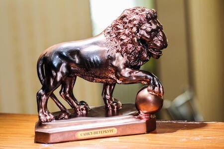 the copper statue of a lion. Vintage bed frame. Wooden headboard.の写真素材
