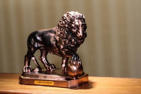 the copper statue of a lion. Vintage bed frame. Wooden headboard.の写真素材