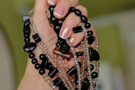 necklace of black stone and crystals in handの写真素材