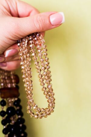 crystal necklace in hand on yellow backgroundの写真素材
