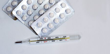 tablets and thermometer with temperature 39 on white backgroundの写真素材