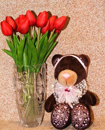 soft toy bear dark brown with tulips near the vaseの写真素材