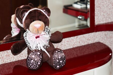 bear toy dark brown on a Burgundy backgroundの写真素材
