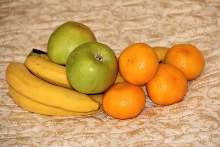 bananas apples tangerines on beige fabricの写真素材