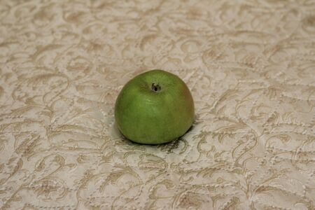 green Apple shining on a light backgroundの写真素材