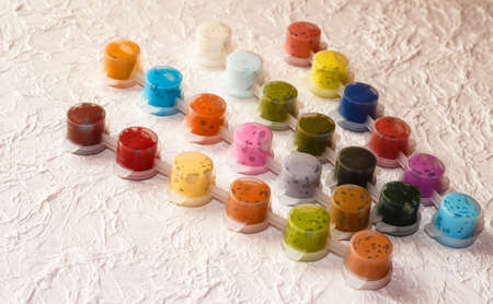 Jars with acrylic paint on a light crumpled background.の写真素材