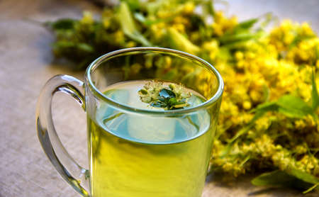 Linden tea with mint leaves and Linden flowers on a linen tablecloth.の写真素材