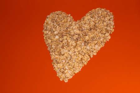 Oatmeal heart on an orange background. Oatmeal on a bright background. Herculesの写真素材
