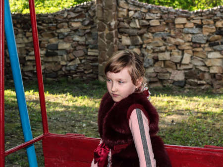 Girl rides on a swing iron. Entertainment for the child. Evening entertainment.の写真素材