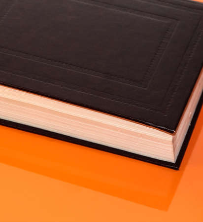 A thick book on an orange background. Background with a book.の写真素材